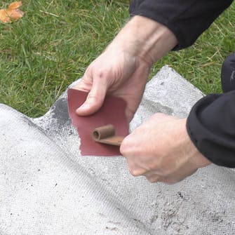 Släpvagn gångjärn: Avlägsna rost från gångjärnet med slippapper Släpvagn gångjärn: Avlägsna rost från gångjärnet med slippapper